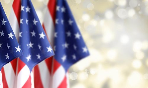 Three American flags in front of blurred background